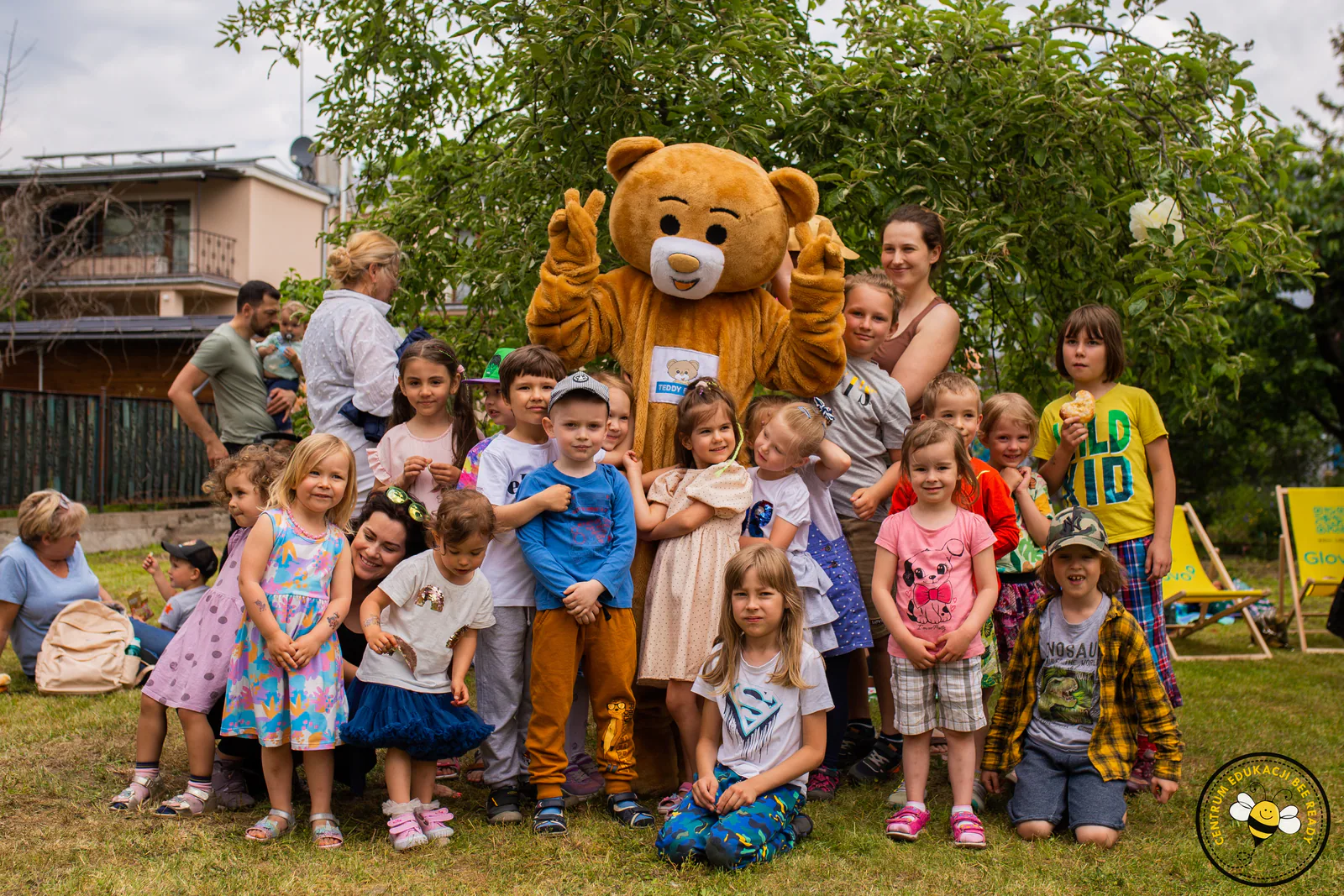 Dzieci i rodzice podczas plenerowego spotkania BeeReady z maskotką Teddy Eddie