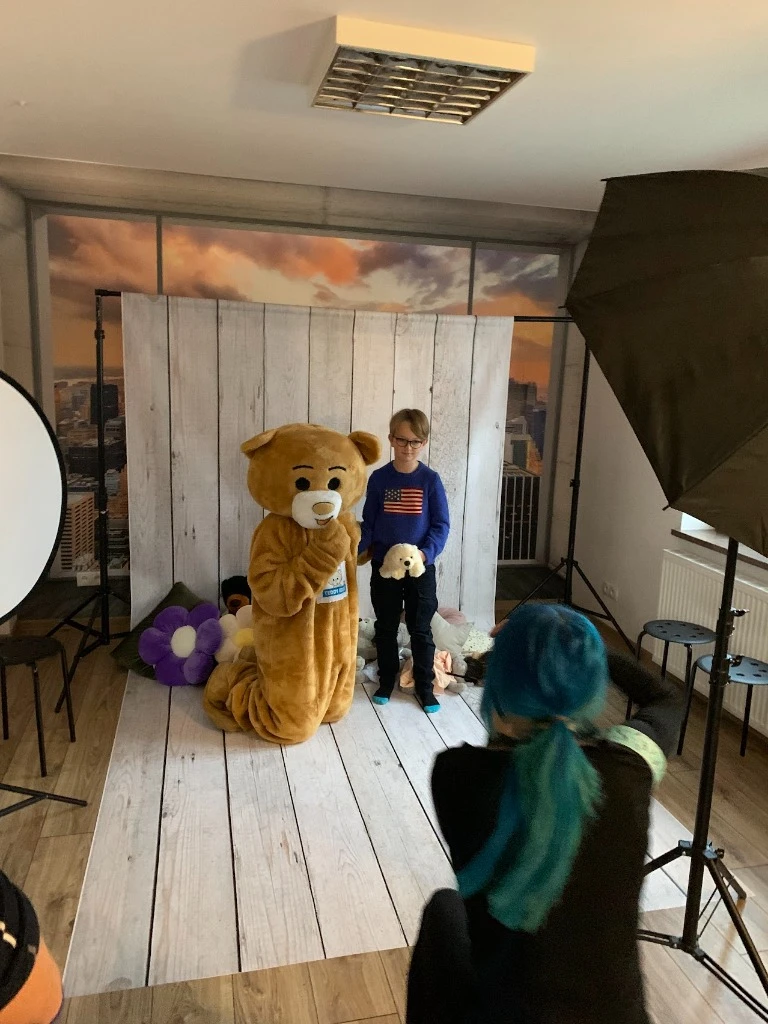 Chłopiec pozujący z maskotką Teddy Eddie podczas rodzinnej sesji zdjęciowej w BeeReady